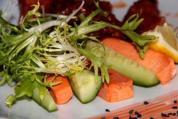 Fresh carrots, cucumber, arugula with lemon and meat.