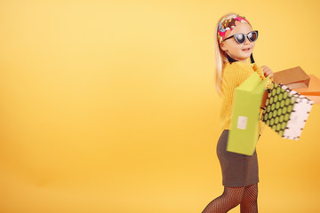 Child with shopping bags. Lady in a yellow sweater