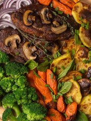 grilled meat steak with vegetables on a wooden board.
