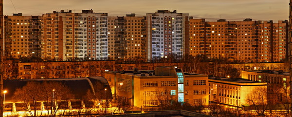 Beautiful multi-storey residential houses in the Moscow district of Konkovo in the winter late evening with amber glowing lighting, panoramic view