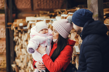 Сute family have fun in a winter park. Woman in a red jacket. Little girl with parents