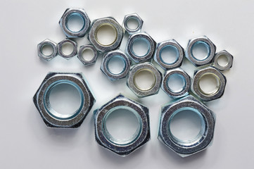 New chrome screw-nut of different sizes on a white background. Concept.