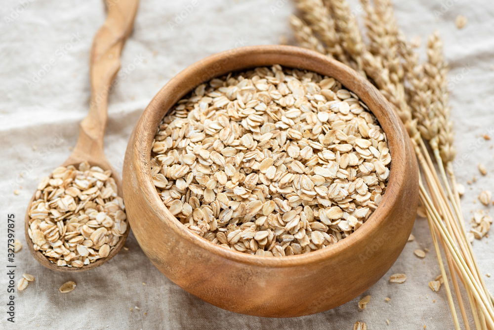 Sticker oat flakes, rolled oats in wooden bowl. healthy food ingredients, low carb dry cereals for porridge,