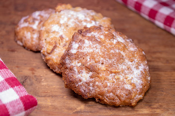 Oatmeal cookies on a wooden table next to a checked towel