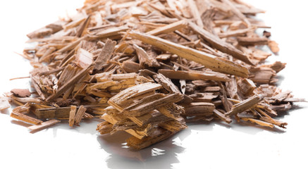Small pile of wood chips biomass for heating industrial boilers isolated on a white background. Raw...