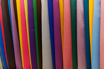 Multi-colored fabrics in a store on the counter. Abstract colorful background. The concept of textiles and products.