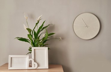 Bouquet of fresh white flowers, empty photo frames with copy space on shelf in front of wall. Mock up with Frame and white flowers. Mother's Day, Women's Day, March 8, spring greeting card template