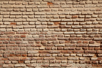 Weathered texture of a traditional brown mud brick wall 