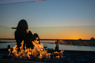 Young Woman enjoying sunset in Marina del Rey in Winter with fire pit