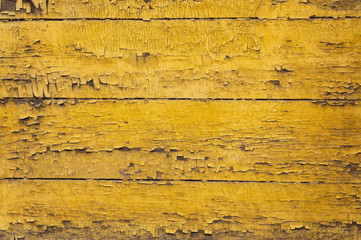 Fototapeta na wymiar Old yellow wooden wall with cracked paint layer. Horizontal wooden planks detailed grunge background texture.