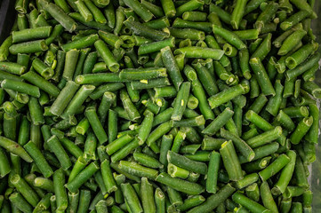 Frozen cut green beans close up texture, food background.