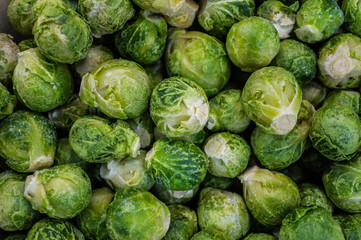 Frozen Brussels sprouts as background, top view. Vegetable preservation in supermarket