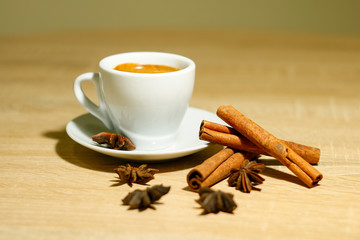 A cup of coffee with heart pattern in a white cup on wooden background