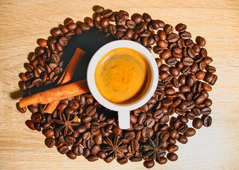 A cup of coffee with heart pattern in a white cup on wooden background