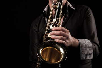 Fototapeta premium Saxophonspieler vor schwarzem Hintergrund