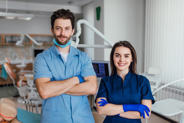 Portrait of smiling dentist standing with arms crossed with her colleague.