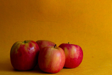 cuatro manzanas sobre fondo amarillo