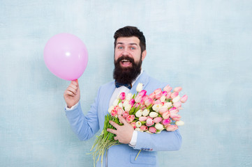 Add holiday cheer with this festive bouquet. Bearded man hold tulips and balloon. Holiday celebration. Happy valentines day. Womens day. Holiday flower arrangement. Make any holiday much more special