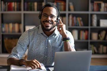 Happy young african american man wearing headset, looking at camera. - Powered by Adobe