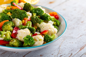 Bowl of fresh vegetable salad on wooden background