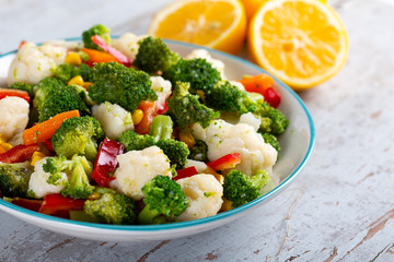 Bowl of fresh vegetable salad on wooden background