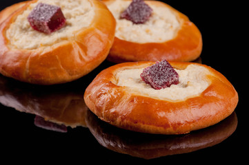  Delicious freshly baked buns with fruits and marmalade. Black background.