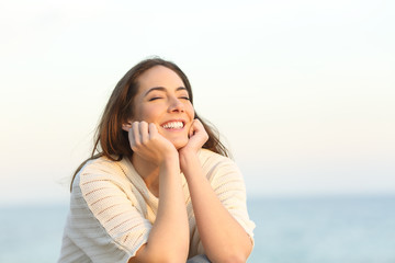 Satisfied woman smiling enjoying a beach day