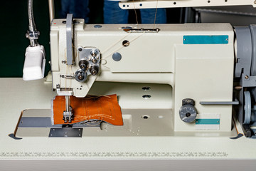 Industrial sewing machine for the manufacture of furniture upholstery from leather and other dense fabrics.