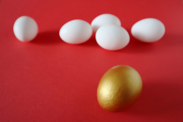 Golden and white eggs lie on a red background. Happy easter concept.