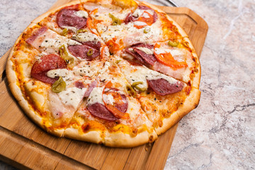 Homemade pizza With pepperoni and cheese on a wooden cutting Board on the table closeup
