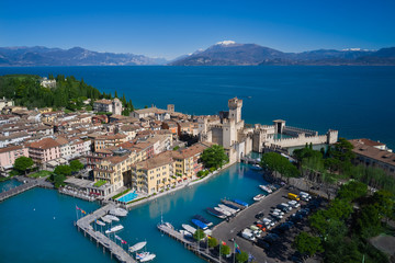 Fototapeta premium Sirmione island Lake Garda, Italy. Aerial view of Sirmione Castle. In the background mountains in the snow and blue sky