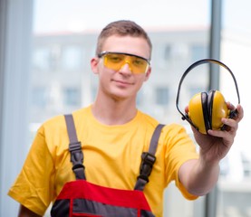 Young construction worker in yellow coveralls