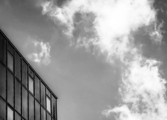 Modern glass building against blue sky with cloud