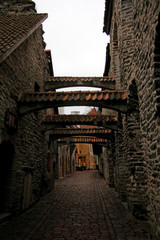 narrow street of the old town with cobblestone pavement and stone walls of houses