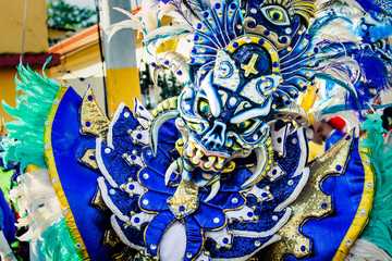closeup human in pied mask and costume poses for photo at dominican carnival