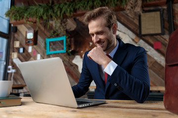 happy businessman working on laptop and smiling