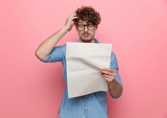 shocked young guy reading newspaper