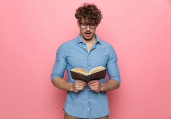 impressed young guy reading a book