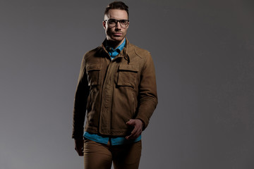 Determined fashion model wearing glasses, walking