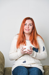 A woman with freckles drinking coffee or tea