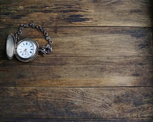 vintage silver pocket watch, old wooden background