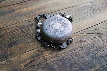vintage silver pocket watch, old wooden background