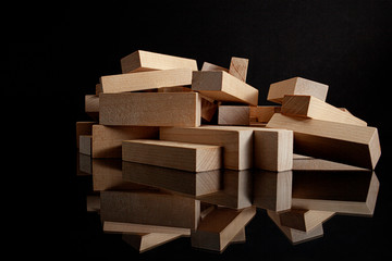 boards on a black background with reflection. wooden items to play with in the tower. wood.