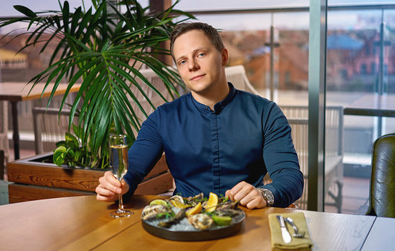 Man Eating Oysters At The Table