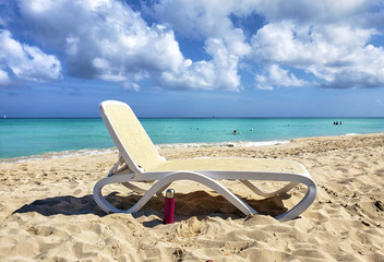 An empty lonely lounger on a sunny day close to and ocean with azure water