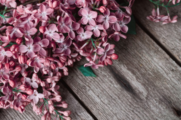 Closeup Purple lilac flowers on a old wooden surface. Spring holidays background.
