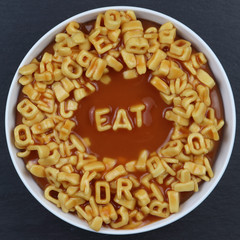 Overhead photo of letter spaghetti in a white round bowl, spells EAT