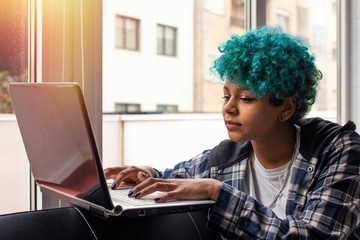 young woman or girl with laptop at home or apartment