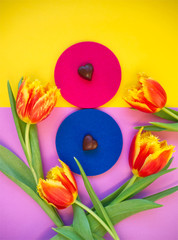 8 march, international woman's day, eight from chocolate pralines, orange tulips on yellow purple background