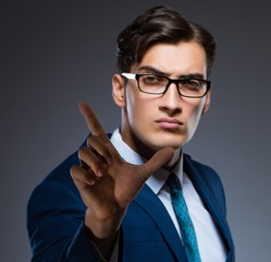 Businessman pressing virtual buttons on gray background